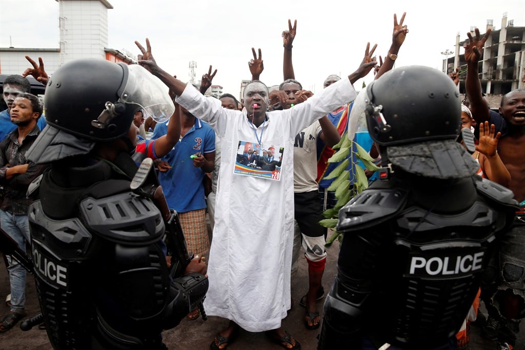 Supporters of Felix Tshisekedi, leader of the Congolese main opposition party, the Union for Democracy and Social Progress, stand in front of police officers as they celebrate his victory in the streets of Kinshasa. Picture: Baz Ratner/Reuters
