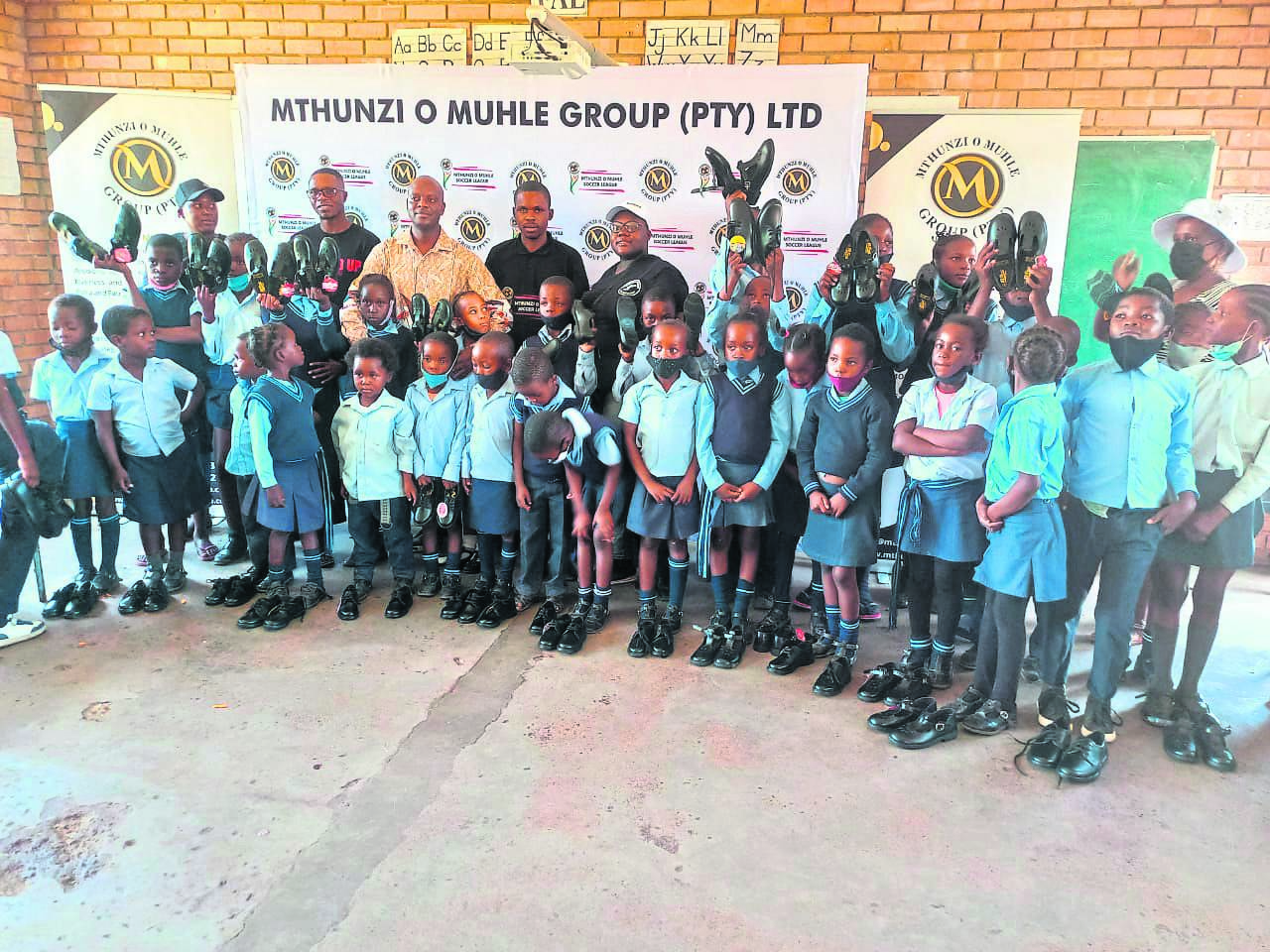 Happy kids of Nwankupana Primary School received new shoes from Adam Sibuyi, CEO of Mthunzi O Muhle Group (third from left, back) and Anonymous Hope Foundation.         Photo by Oris Mnisi