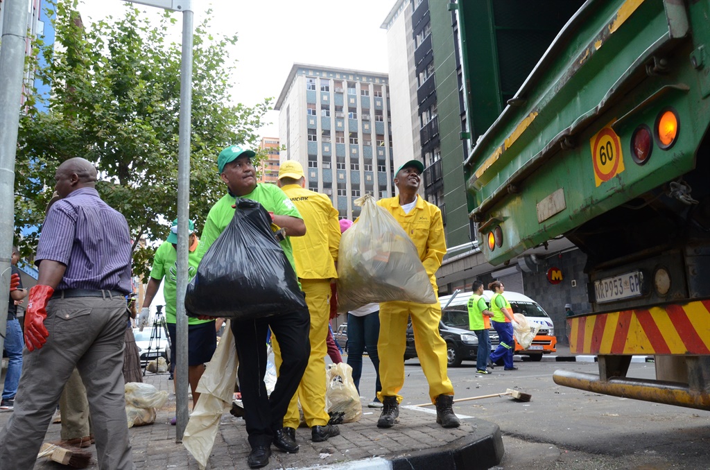Mayor Parks Tau (right) and other city managers clean up after Pikitup strikers trashed Joburg's streets. Photo by Zamokuhle Mdluli 