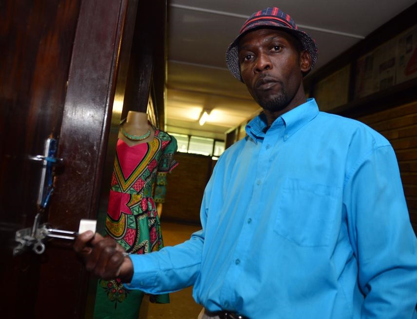Johannes Ntsele locking the door of a Joburg sangoma's indumba earlier this week. Photo by Lucky Morajane