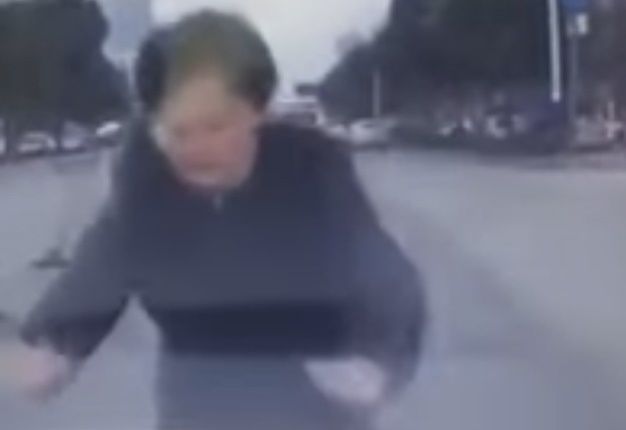 <b> FAIL!: </b> A Chinese woman was caught on dash cam attempting to execute a scam by launching herself in front of a car, fortunately the driver was two steps ahead. <i> Image: YouTube </i>