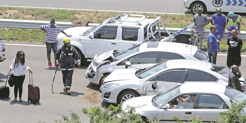 DJ Cndo takes her bags to another car after she was involved in a seven-vehicle accident on the N2 outside Durban.                 Photo by Jabulani Langa 