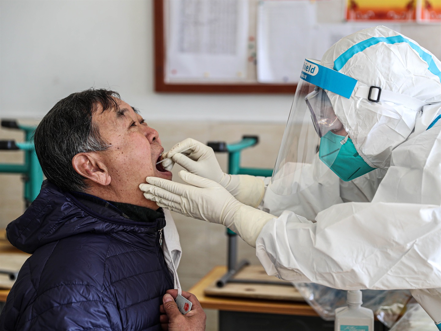 A medical worker takes a swab sample from a patient.