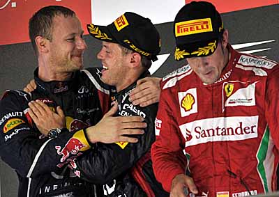  <b>HUGS ALL ROUND:</b> Winner Red Bull's Sebastian Vettel (centre) gets in a clinch with team mechanic Ole Schack while third-placed Ferrari driver Fernando Alonso looks coy after the 2012 Singapore F1 GP. <i>Image: AFP</i>