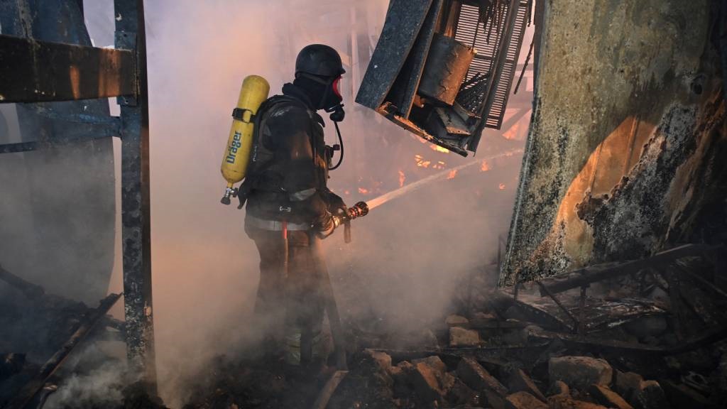 A Ukrainian firefighter intervenes to extinguish a
