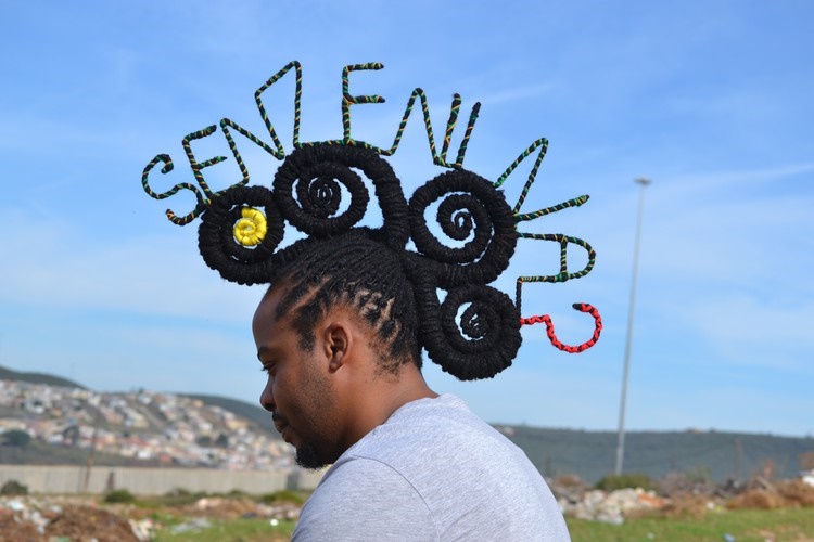 Hair stylist Onele Cembi twists his dreadlocks into the words 'Senzenina'. 