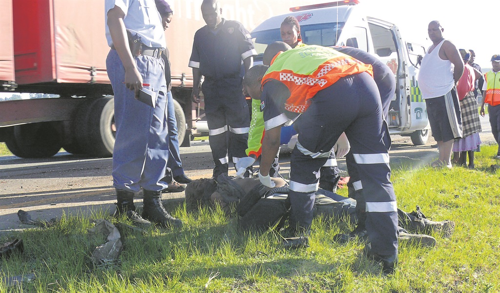 Paramedics hopelessly try to revive the bakkie driver at the accident scene.                                                Photo by Monwabisi Khininda 