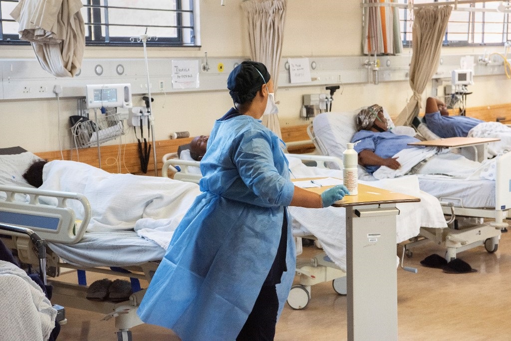 A hospital worker walks amongst patients with Covid-19 in the Covid-19 ward at Khayelitsha Hospital.