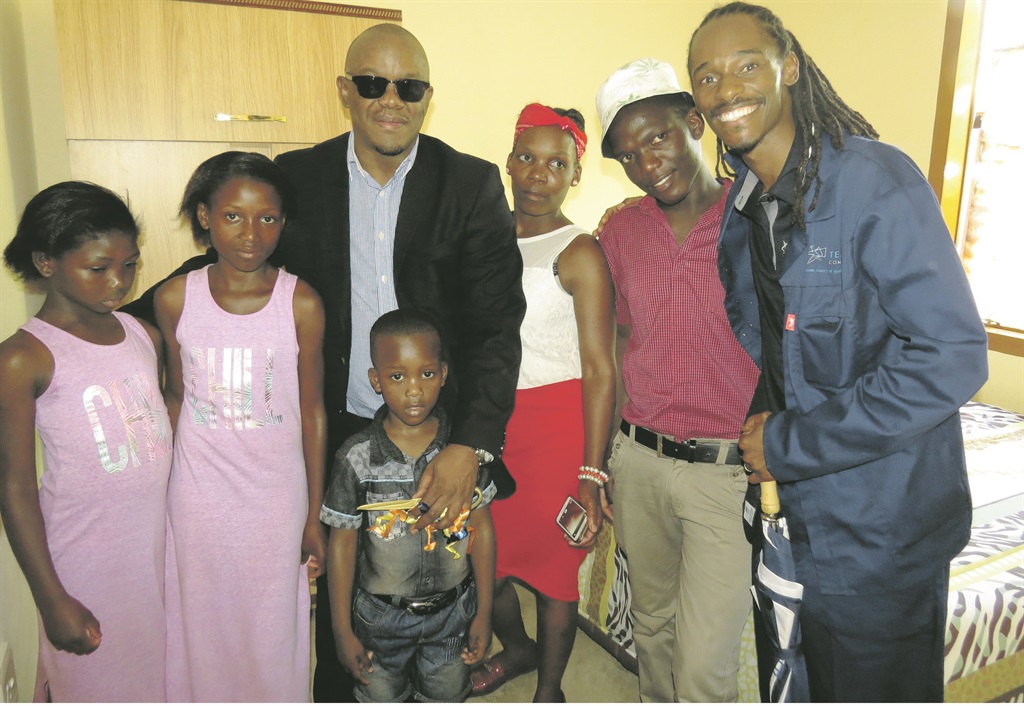 Keith Khoza of Gauteng human settlements (third from left) and Freedom Hadebe of Temi Construction (right) with the happy Mdluli family after they received their new house (inset) in Lawley, Vaal.             