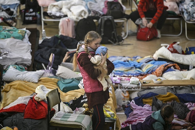 A girl holds her sibling in a temporary shelter for Ukrainian refugees in a school in Przemysl, near the Ukrainian-Polish border. 
