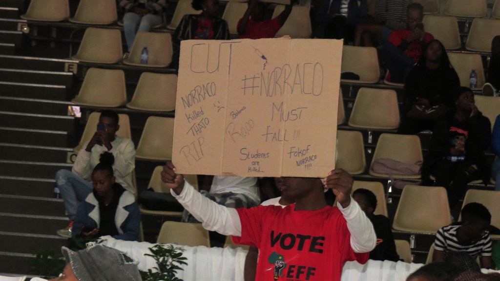 An aggrieved unidentified student at the Central University of Technology, Free State holds aloft a poster bearing a message of frustration regarding overdue Nsfas funds payment and subsequent brutal killing of a fellow student.