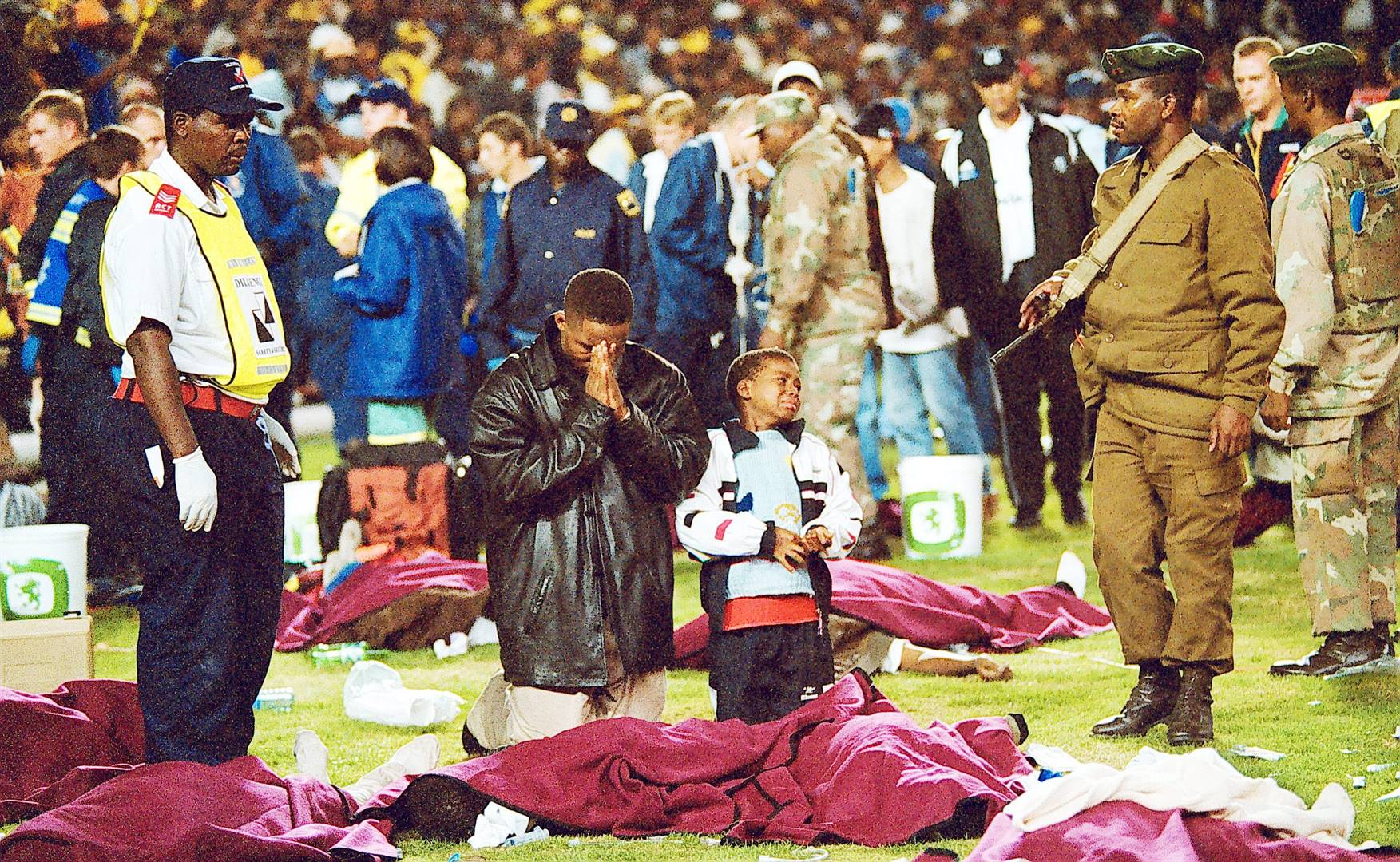 Family pray over their loved ones in the aftermath of the Ellis Park stampede in Johannesburg on April 11 2001. Photo: Gallo Images/City Press/Mpho Mphotho
