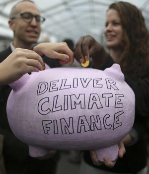 Participants contribute coins into a piggy bank during the World Climate Change Conference 2015 (COP21) at Le Bourget, near Paris, France. Picture: Stephane Mahe/Reuters