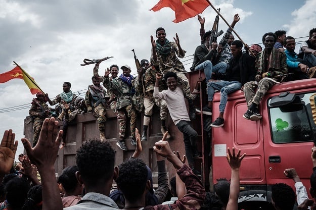 Tigray Peoples Liberation Front fighters react to people from a truck as they arrive in Mekele, the capital of Tigray region, Ethiopia. 