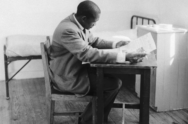 Robert Sobukwe reads a newspaper and smokes in his cell at the prison on Robben Island. He was imprisoned from 1960 until his death in 1978. (Bettmann/Getty Images)