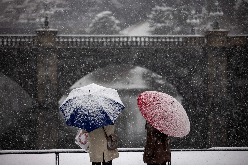 A couple hold their umbrella as snow falls near the Imperial Palace in Tokyo on January 6, 2022.
Behrouz MEHRI / AFP