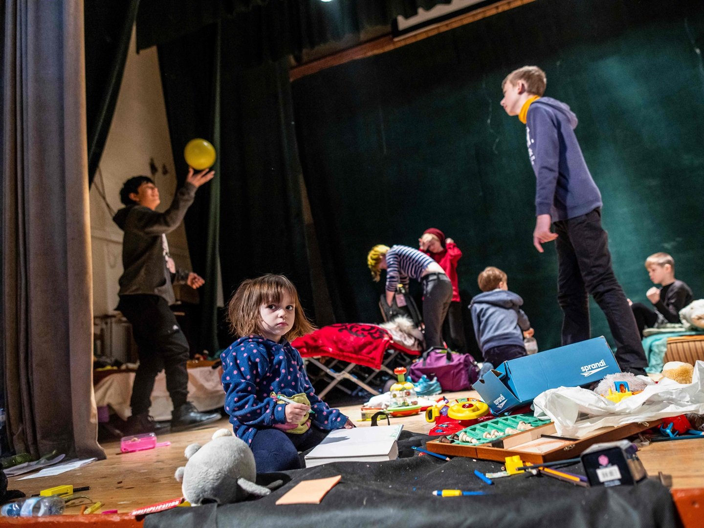 Children play on the stage of the theatre of the Ukrainian House where a shelter for refugees is installed in Przemysl, south eastern Poland, near the Ukrainian-Polish border.