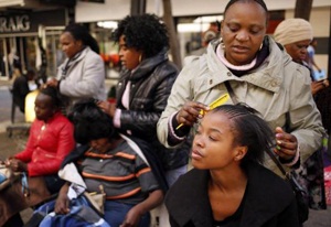 Hairdressers attend to clients in downtown Johannesburg
