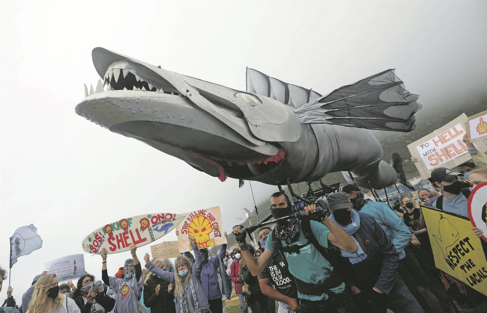 Betogers neem Sondag met ’n vis-marionet deel aan ’n betoging op Muizenberg se strand. Foto: Reuters 