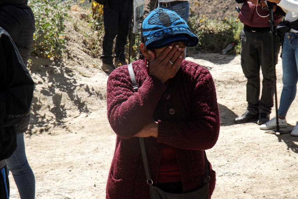 A relative of a miner cries as she waits at the en