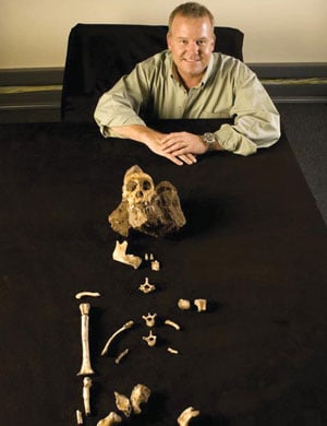 Professor Lee Berger poses with parts of Karabo, the prehistoric man who is providing answers about humankind. Picture: Wits