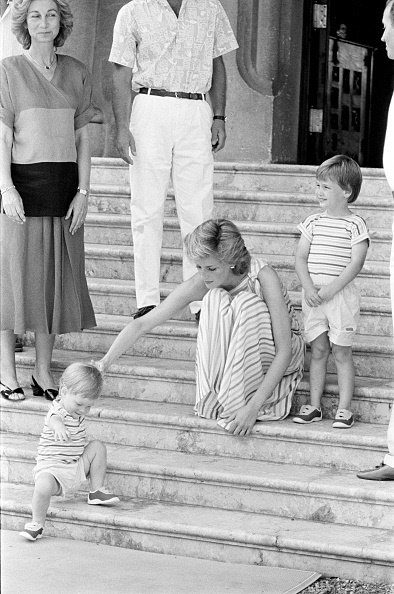 Princess Diana helps her nearly 2- year-old son, P
