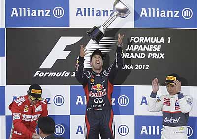 <b>'DON'T DROP IT!'</b> Red Bull driver Sebastian Vettel plays catch with his trophy after winning the 2012 Japanese F1 GP; third-placed Sauber driver Kamui Kobayashi looks on as second-placed Felipe Massa of Ferrari gets his prize. <i>- AP</i>