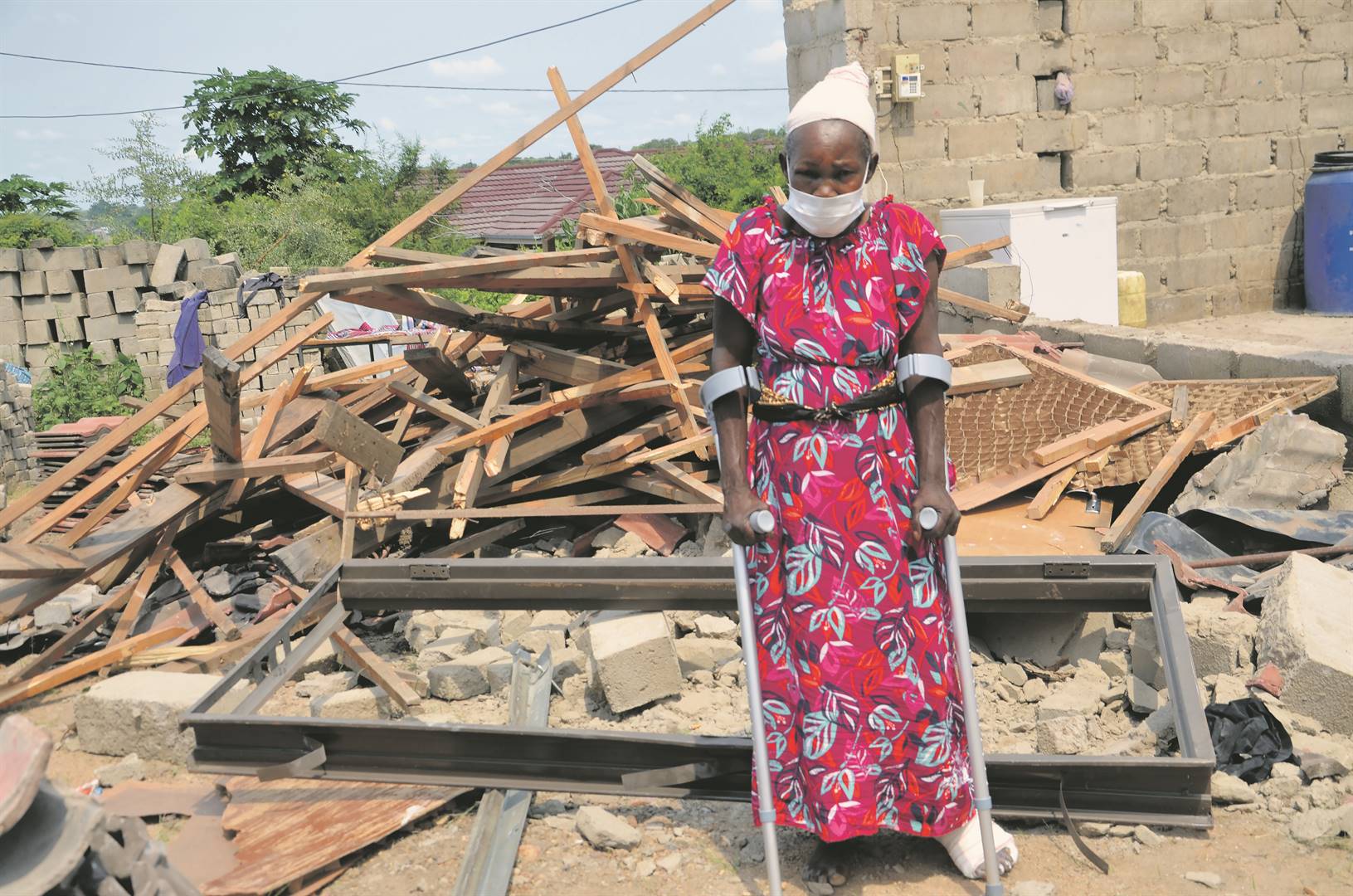 NGICISHE NGAFA: Gogo Alice Masiya, standing on crutches in front of the rubble after the roof of her garage collapsed on her, is grateful to be alive.            Photo by        Oris Mnisi