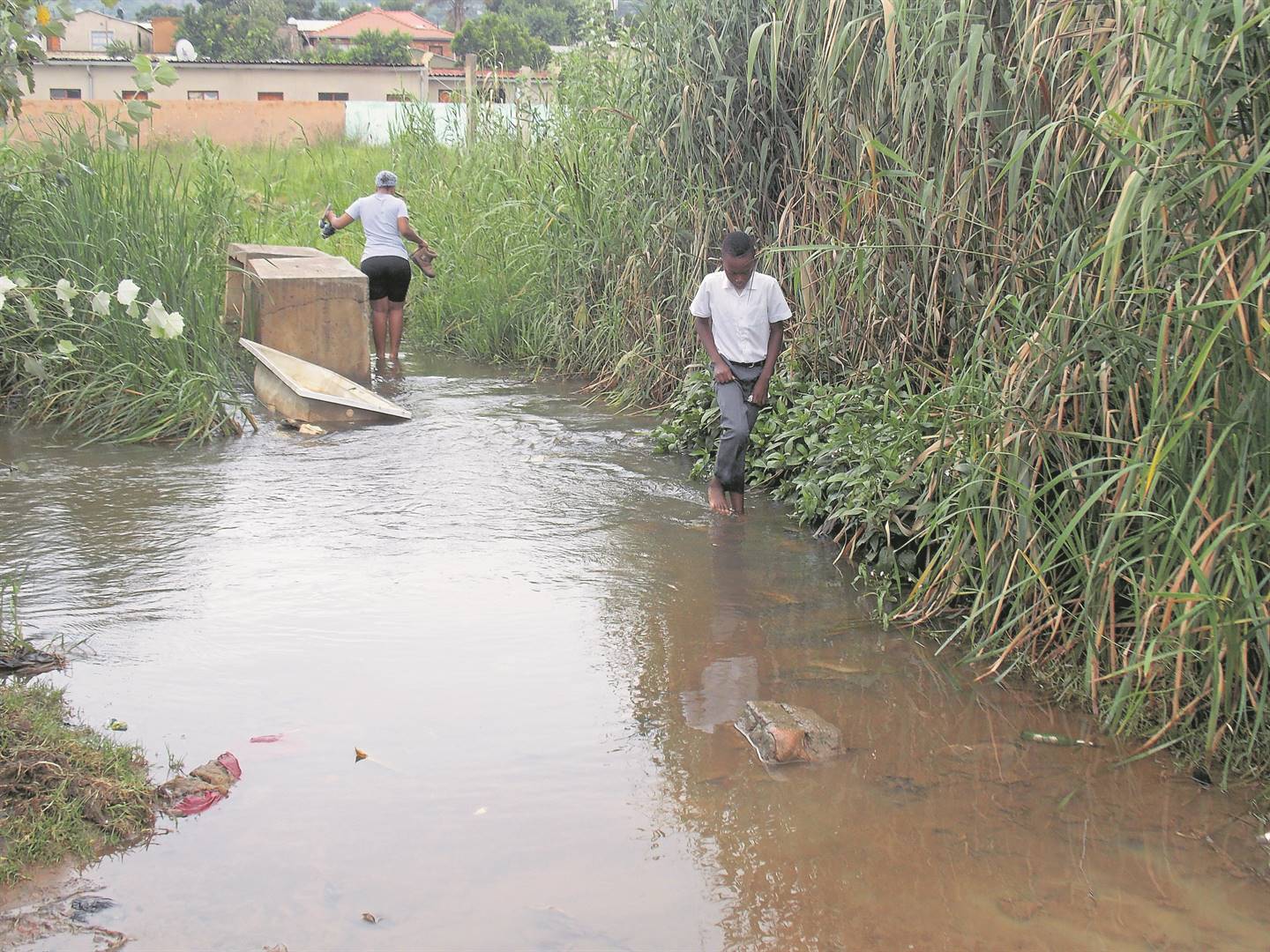 Pupils from Mamelodi extension 18 in Tshwane have to endure the hardship of crossing a stream.      Photo by Aaron Dube