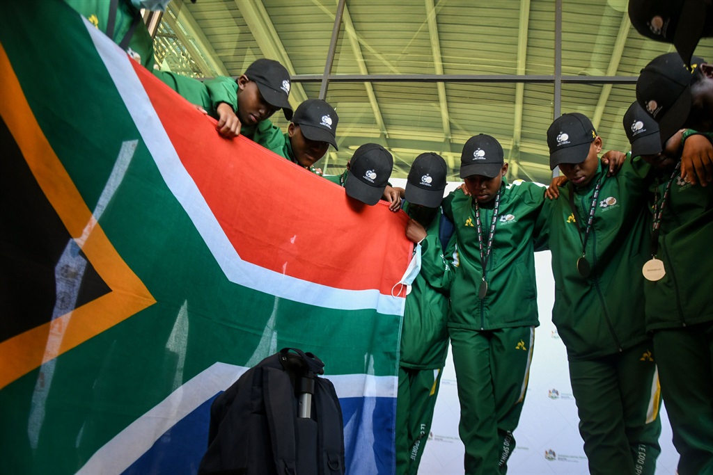 Members of the The Edendale Technical school ladies soccer team  pray with the SA flag at King Shaka International Airport earlier this year (Photo by Gallo Images/Darren Stewart)
