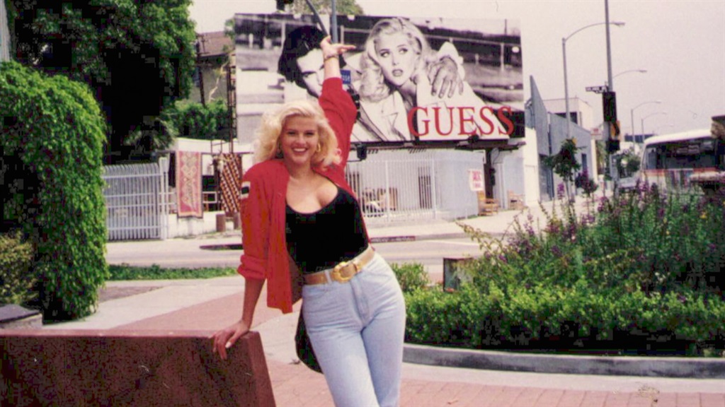 Anna Nicole Smith posing with her Guess billboard 