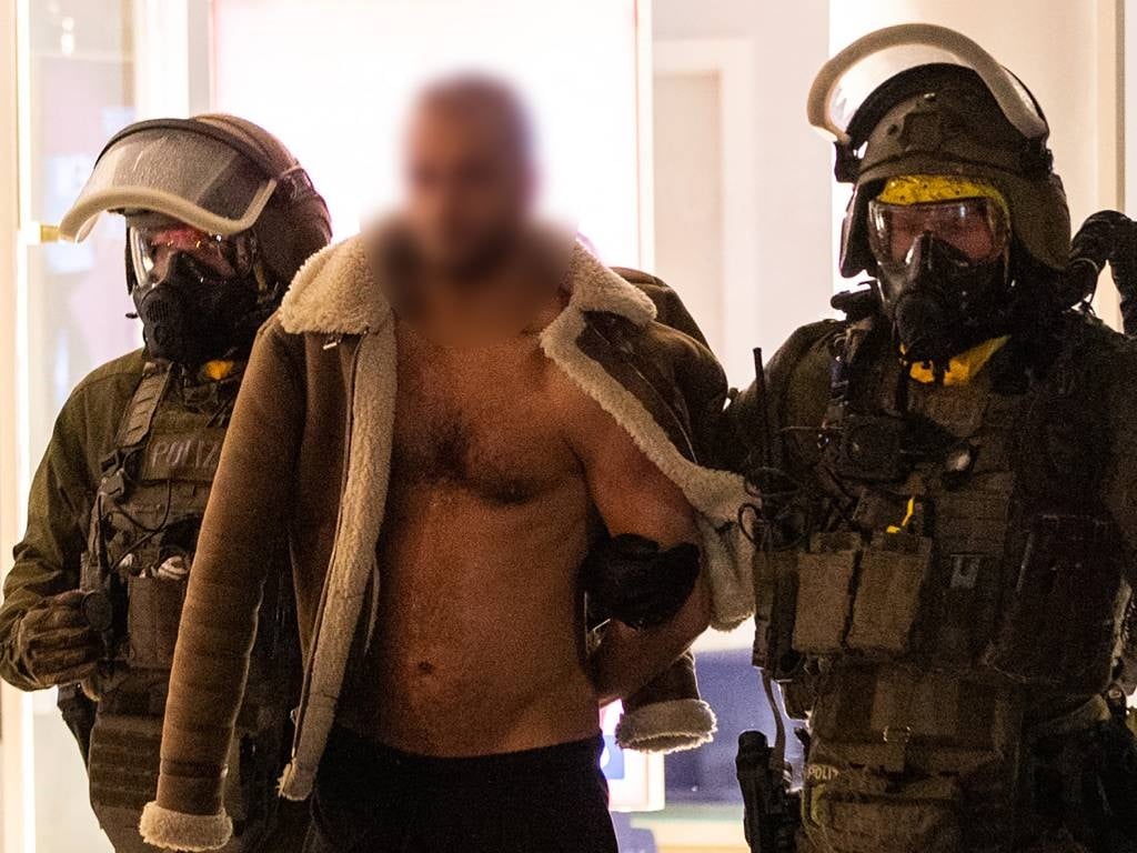 A man (C) is led away following his arrest by a Special Task Force (SEK) police officers wearing protective gear in Castrop-Rauxel, western Germany.