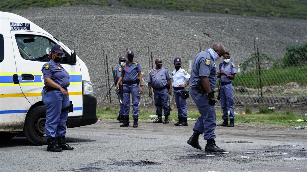 Police remove debris following protest action in Kroondal in the North West on 12 January 2021. 