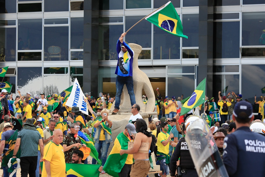 Supporters of Brazilian former President Jair Bolsonaro invade Planalto Presidential Palace while clashing with security forces in Brasilia on January 8, 2023. 