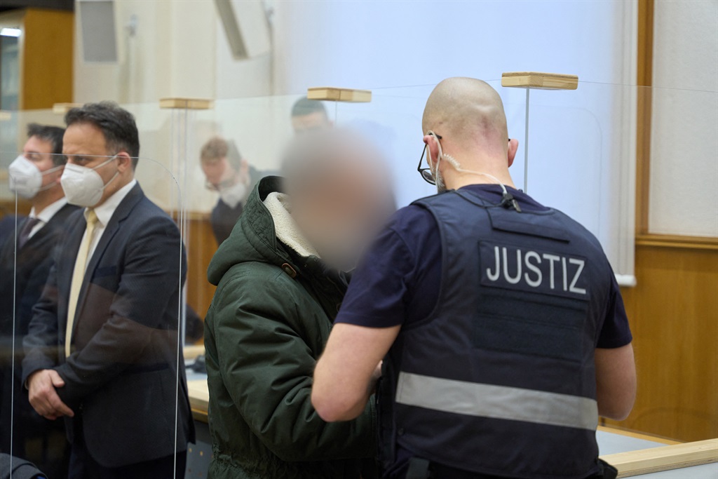 Former Syrian intelligence officer Anwar Raslan (C) arrives in the courtroom at a courthouse in Koblenz, western Germany, on January 13, 2022 on the last day of his trial where he was sentenced to life in jail for crimes against humanity in the first global trial over state-sponsored torture in Syria. Anwar Raslan, 58, was found guilty of overseeing the murder of 27 people at the Al-Khatib detention centre in Damascus, also known as "Branch 251", in 2011 and 2012.  Thomas Frey / POOL / AFP