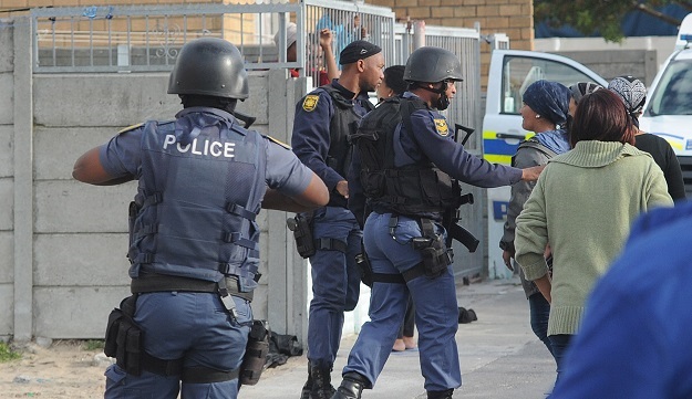 Police officers attend to a crime scene in Mitchells Plain.