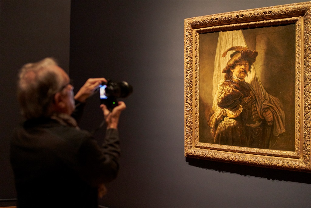 A visitor takes photographs of the painting by Rembrandt The Standard-bearer, during the exhibition at the Rijksmuseum, in Amsterdam, Netherlands. The exhibition, a partnership between the Rijksmuseum and the Museo Nacional del Prado in Madrid, explores the link between Dutch and Spanish painting traditions.