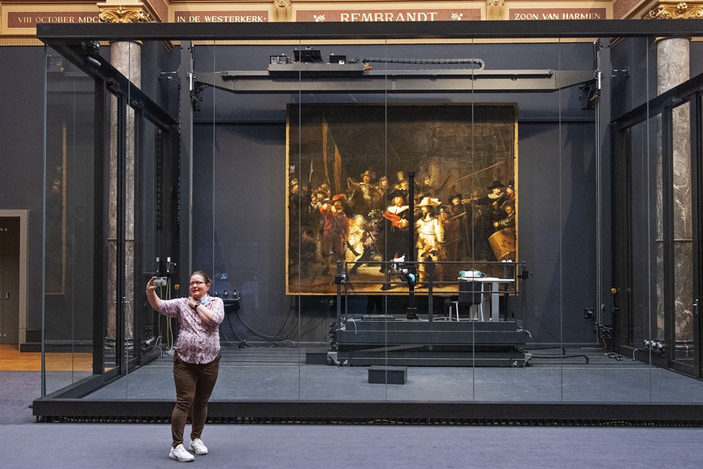 A visitor poses for a 'selfie' with 'The Nightwatch' painting by Rembrandt on display at The Rijksmuseum in Amsterdam on June 5, 2021. which along with other museums in the country has re-opened after a relaxation of coronavirus (Covid-19) rules after almost six months of closure. (OLAF KRAAK / ANP / AFP)