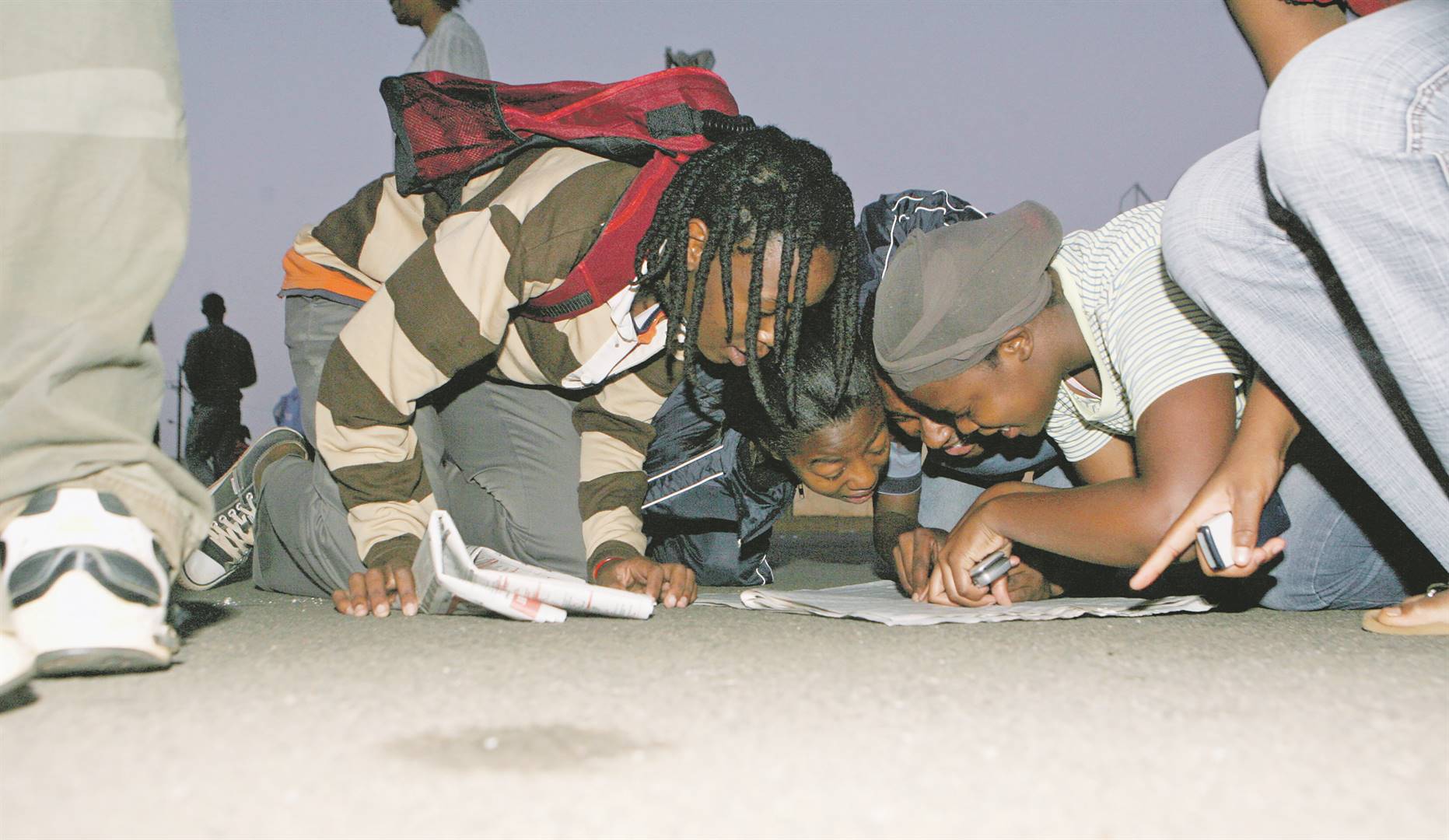 scouring the paper Matriculants search for their names and results. Photo: Mlandeli Puzi
