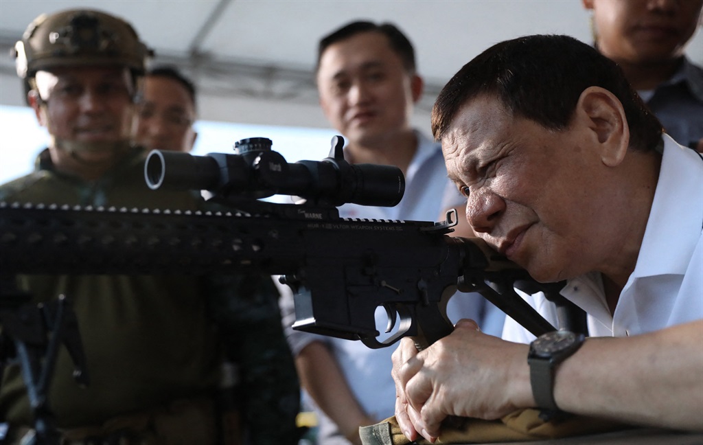 This photo taken and released by Presidential Photographers Division (PPD) on March 1, 2018 shows President Rodrigo Duterte firing a few rounds with a sniper rifle during the opening ceremony of the National Special Weapons and Tactics (SWAT) Challenge in Davao City, southern Philippine island of Mindanao.