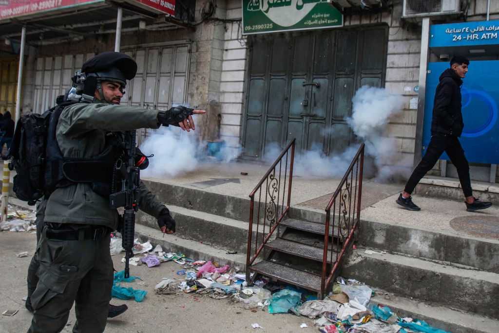 An Israeli border guard fires stun grenades at the Palestinian demonstrators, during a Land Day demonstration in the Palestinian town of Huwara in the occupied West Bank. Land Day commemorates the events of March 30, 1976, when Israeli troops shot and killed six people among Arab Israelis and Palestinians protesting against land confiscations. (Photo by Nasser Ishtayeh/SOPA Images/LightRocket via Getty Images)