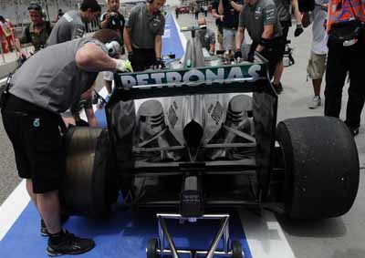 <b>GRID PENALTY LOOMING:</b> Mechanics work on Lewis Hamilton's Mercedes after a blown tyre damaged his gearbox ahead of the 2013 Bahrain F1 GP. He got a five-place grid penalty for gearbox replacement. <i>Image: AFP</i>
