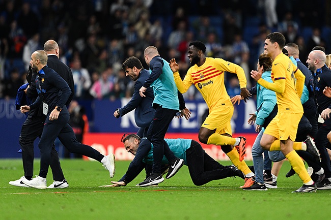 Players and staff of FC Barcelona attempt to leave the pitch as fans of RCD Espanyol attempt to invade the pitch. (Photo by David Ramos/Getty Images)