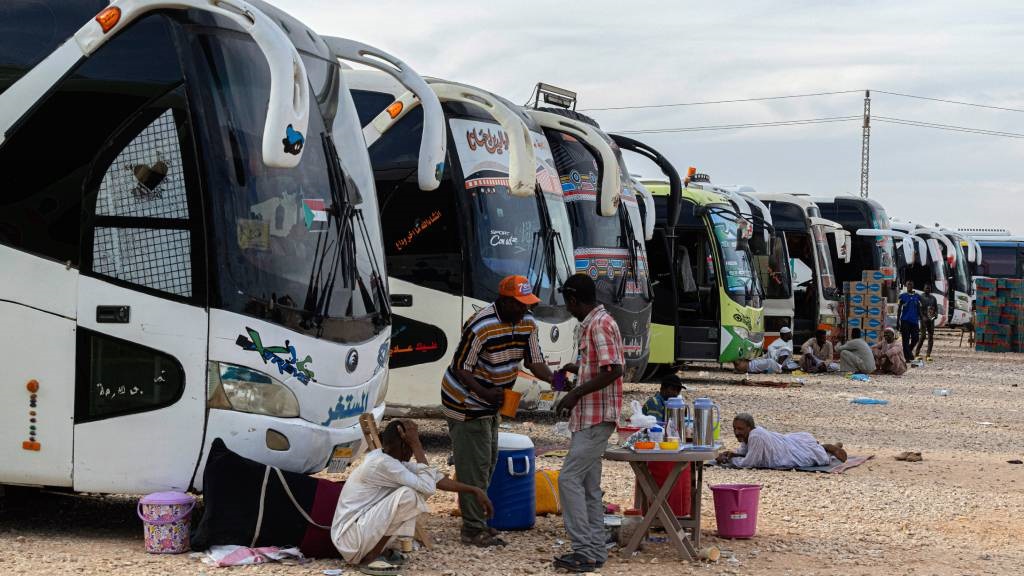 Conductores sudaneses que descansan al lado de los autobuses
