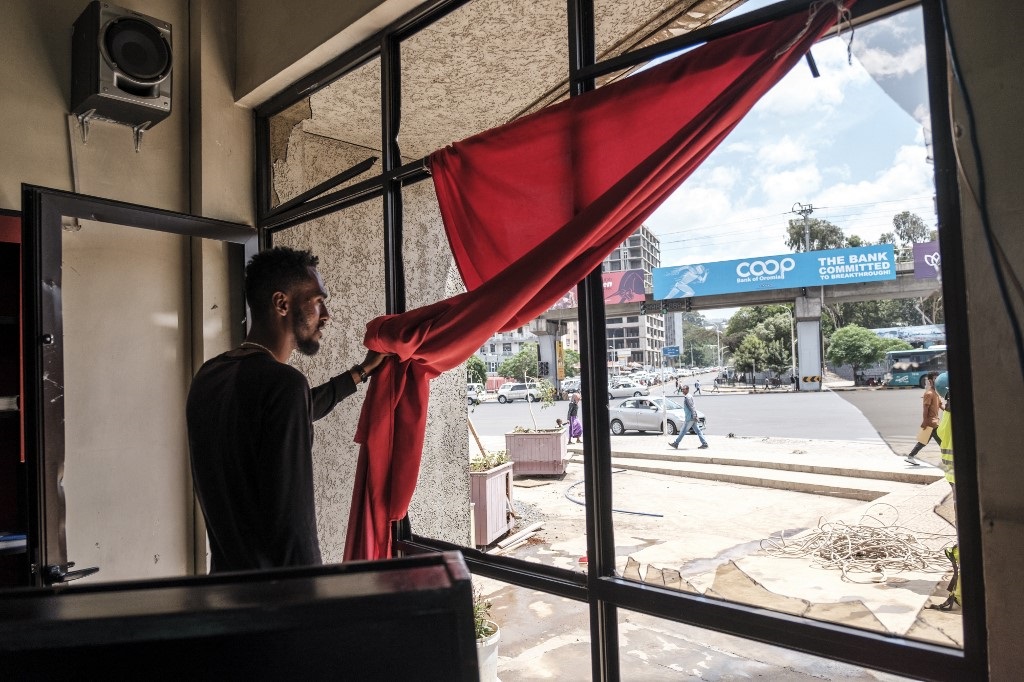 A worker holds a curtain as he shows a damaged window in a bookshop in the city of Addis Ababa, Ethiopia, on May 3, 2022. Ethiopian police briefly clashed with young Muslims in Addis Ababa on May 3, 2022 during prayers to mark the end of Ramadan.