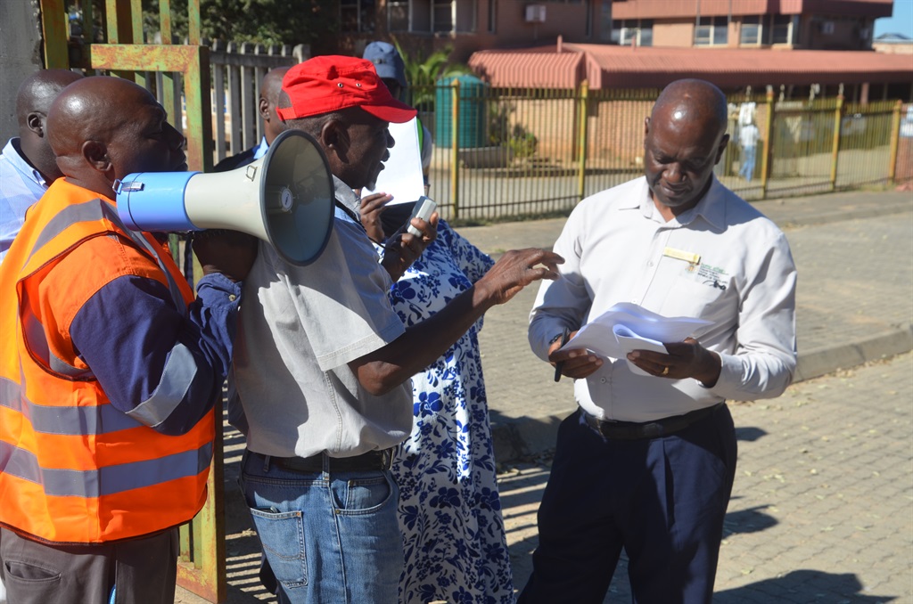 Mhala Home Affairs manager, Robert Khoza (right), received and signed the memorandum from Velly Manzini (wearing a red cap) and Paulos Mlambo. Photo by Oris Mnisi