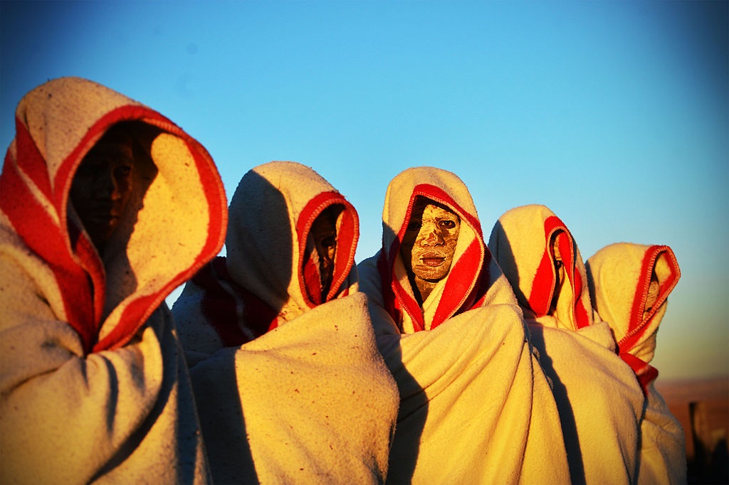 Initiates are smeared with white clay on their face and are covered in red and white blankets on in Ngunjana Village, Eastern Cape. 
