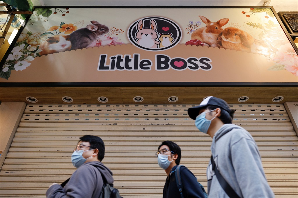 People stand in front of a temporarily closed pet shop after the government announced to euthanize around 2,000 hamsters in the city after finding evidence for the first time of possible animal-to-human transmission of coronavirus disease (COVID-19) in Hong Kong, China, January 18, 2022. REUTERS/Tyrone Siu