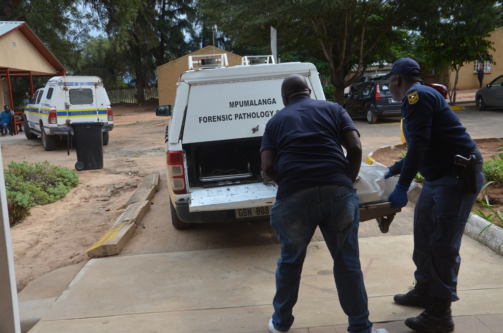 A pathologist and an officer taking Khensani Ndlovu's body to a mortuary vehicle. Photo by Oris Mnisi 