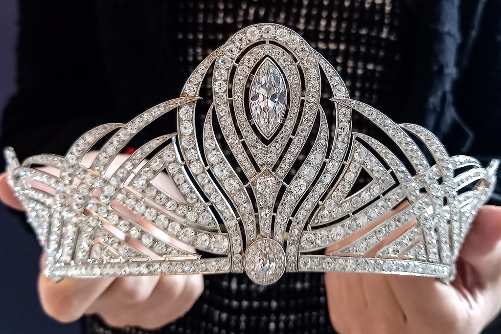 This photograph taken on May 15, 2023, in Geneva, shows an employee of Christie's auction house holding the Bessborough Diamond Tiara, expected to fetch between 890,000 to 1,67 million USD during the "Magnificent Jewels" sales. 
